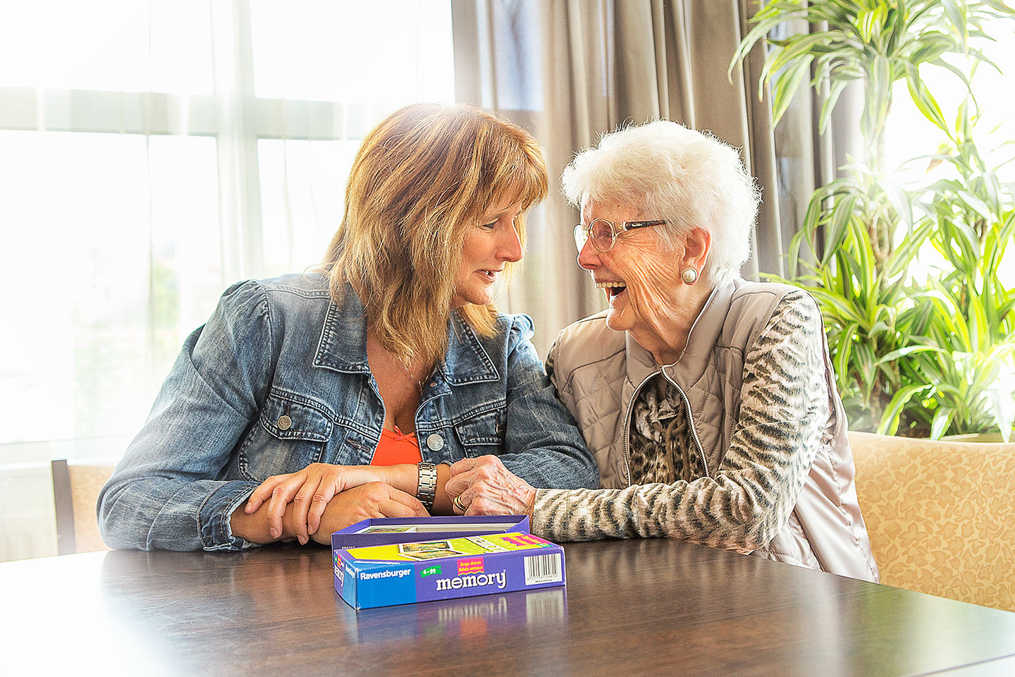 vrijwilligster speelt memory met bejaarde vrouw ouderenzorg