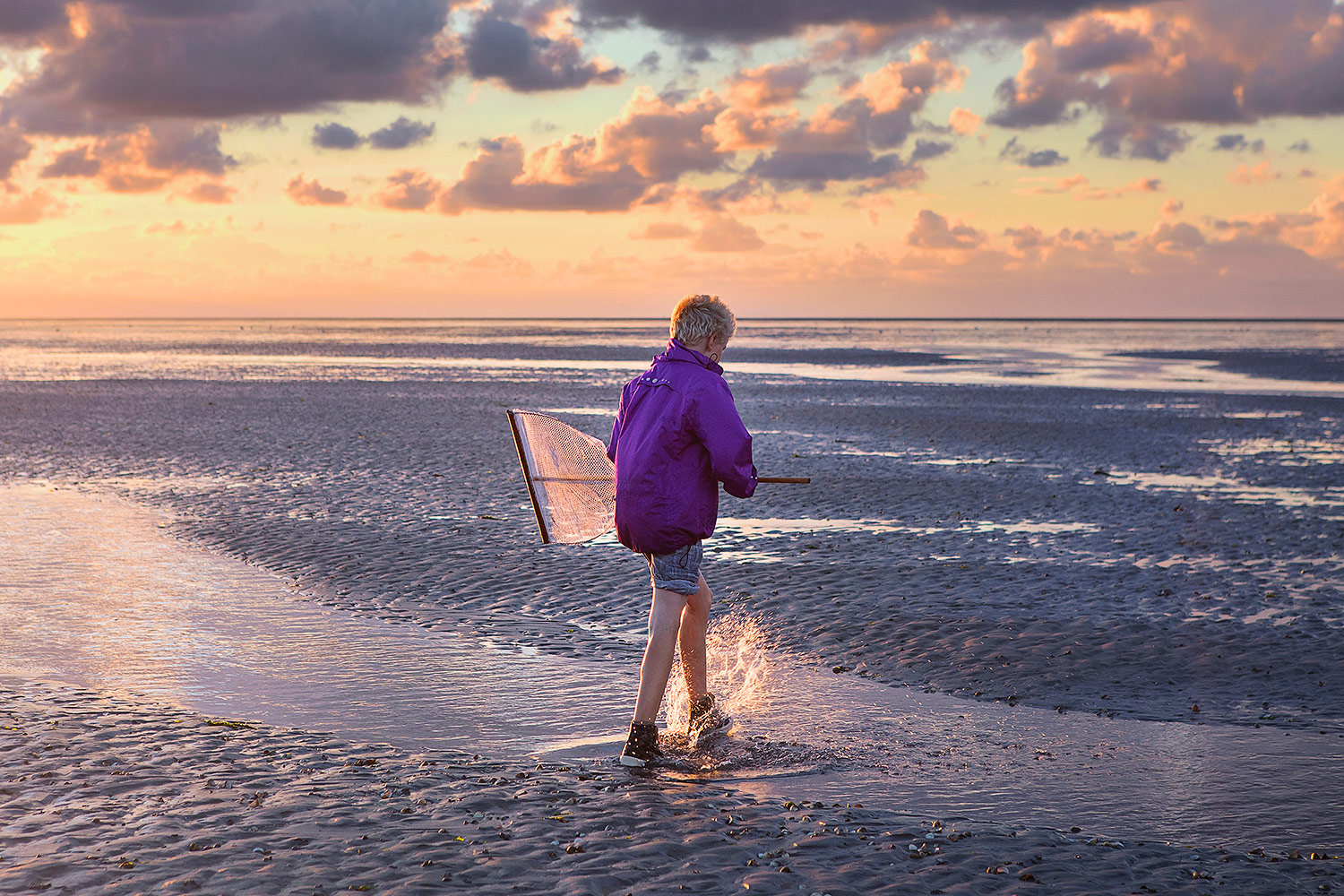 wadlopen zonsondergang op strand kind met visnet - Martin Rijpstra fotograaf Leeuwarden